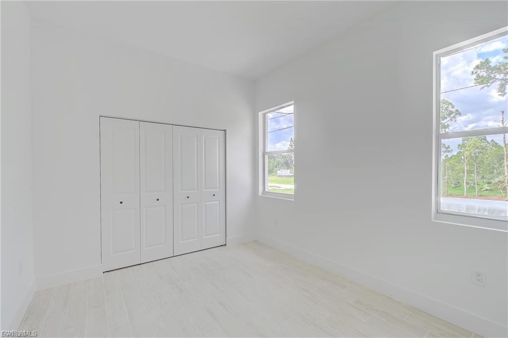Unfurnished bedroom with light wood finished floors and a closet