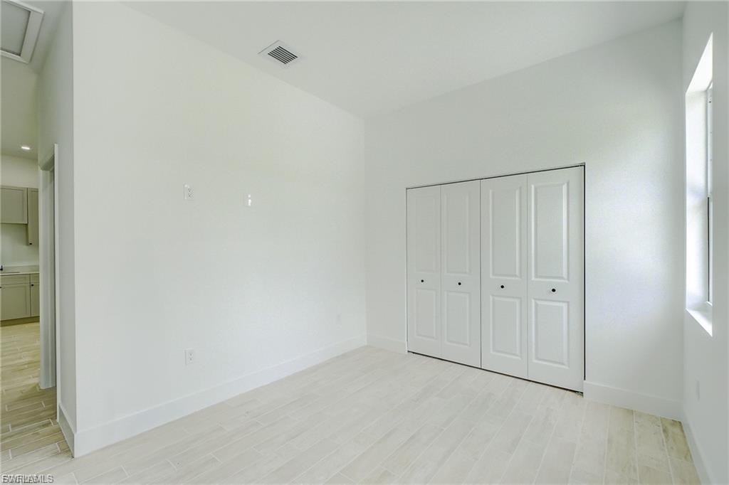 Unfurnished bedroom with light wood finished floors and a closet
