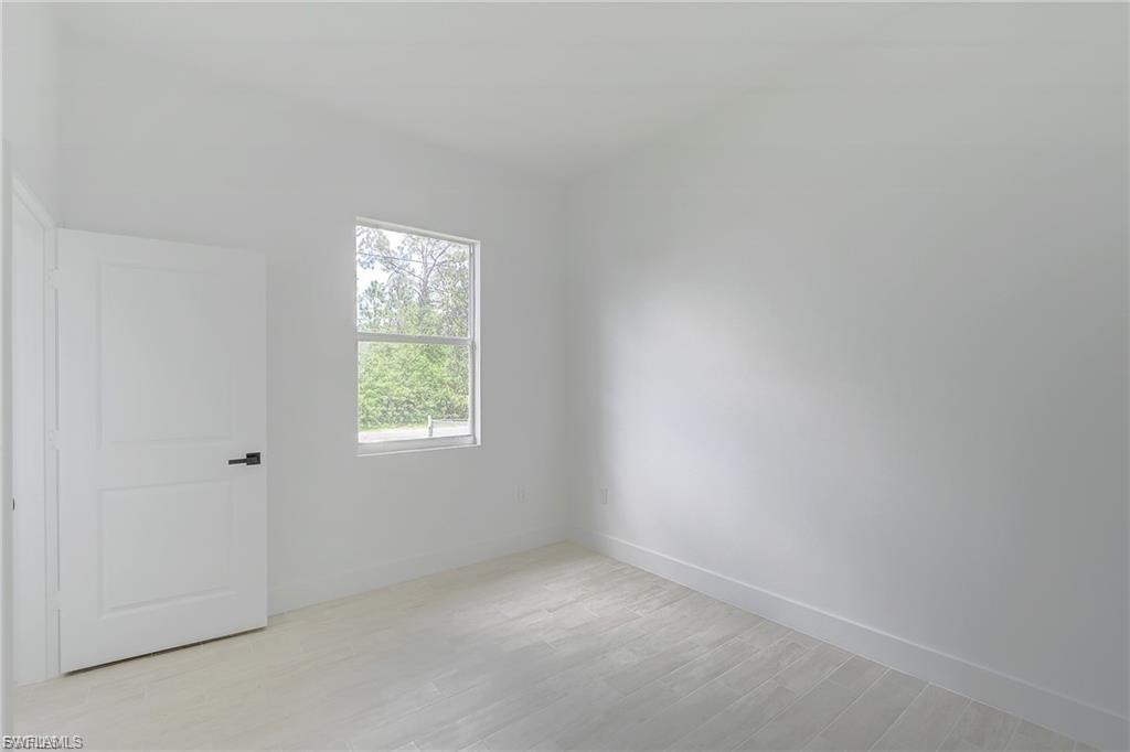Empty room with light wood finished floors