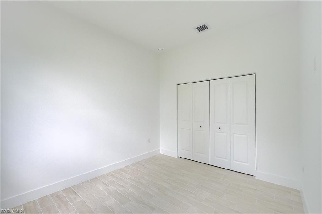 Unfurnished bedroom with light wood-style floors and a closet