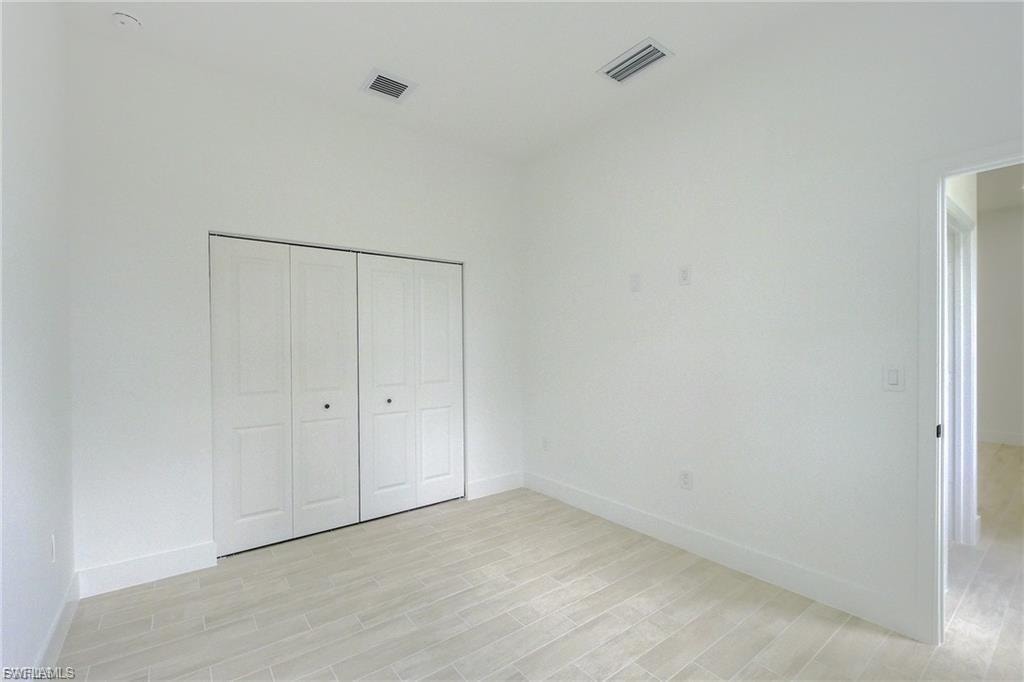 Unfurnished bedroom featuring light wood-style flooring and a closet