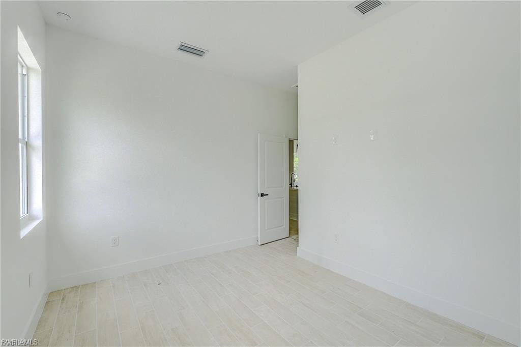 Unfurnished room featuring light wood-type flooring and baseboards