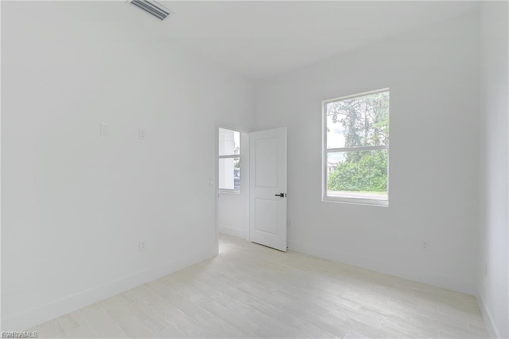 Unfurnished room with light wood-type flooring and baseboards