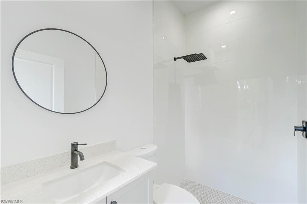 Bathroom with vanity and tiled shower