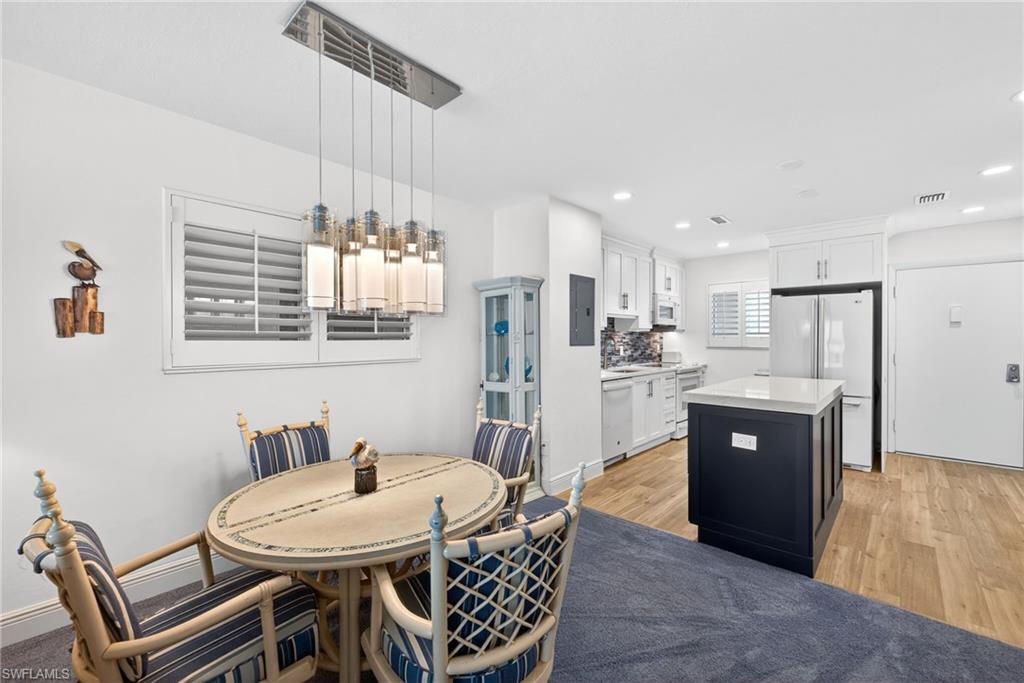 Dining space featuring light wood-style floors, recessed lighting, and electric panel