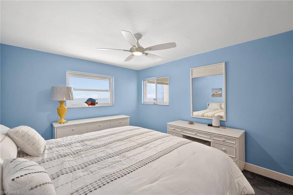 Bedroom featuring a ceiling fan and dark carpet