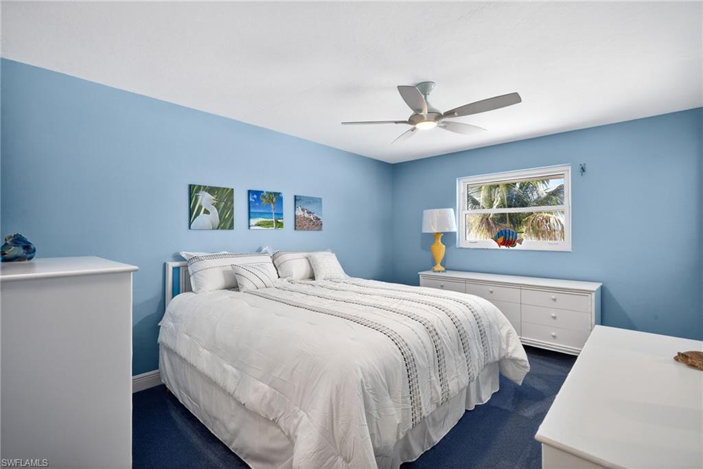 Bedroom featuring a ceiling fan and dark carpet