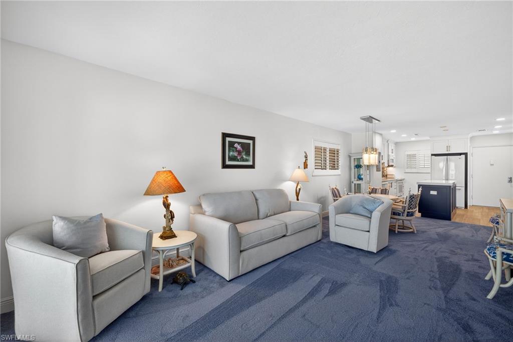 Living room featuring dark colored carpet and recessed lighting