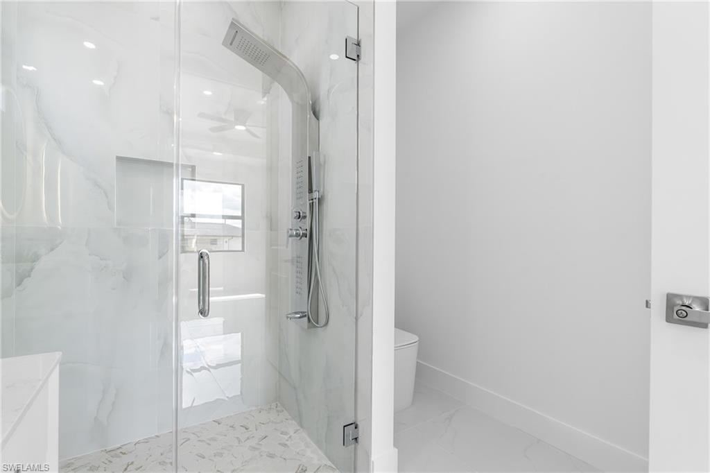 Full bathroom featuring a marble finish shower and light marble finish floors
