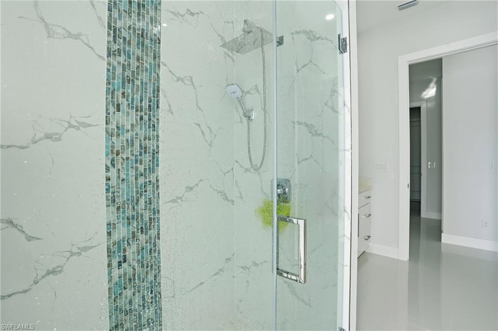 Full bathroom with a marble finish shower and vanity