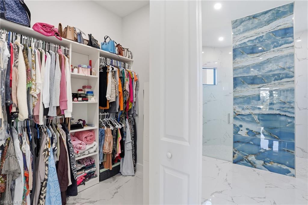 Walk in closet with light marble finish floors