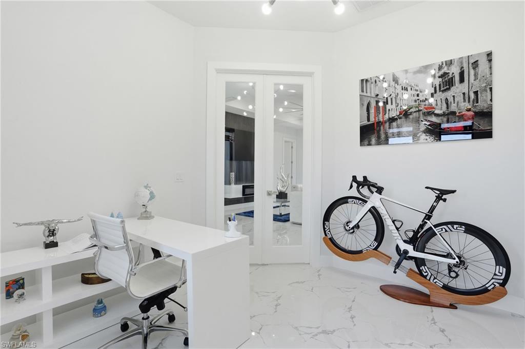 Office area featuring french doors and light marble finish floors
