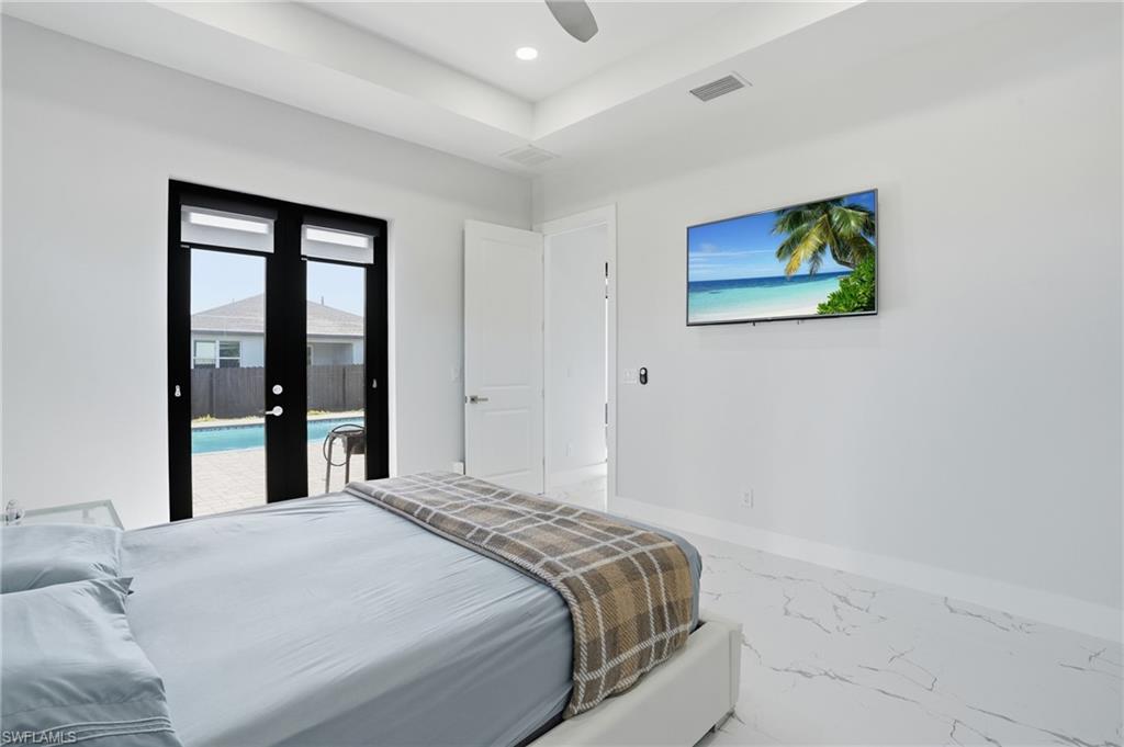Bedroom with access to outside, ceiling fan, marble look tiles, recessed lighting, and french doors