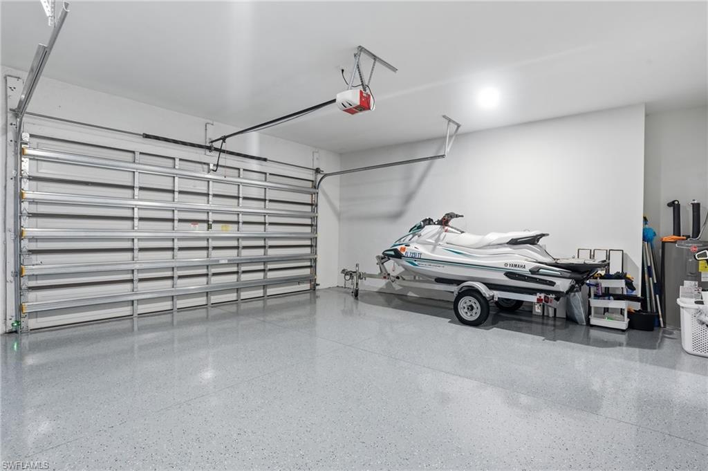 Garage featuring water heater and a garage door opener