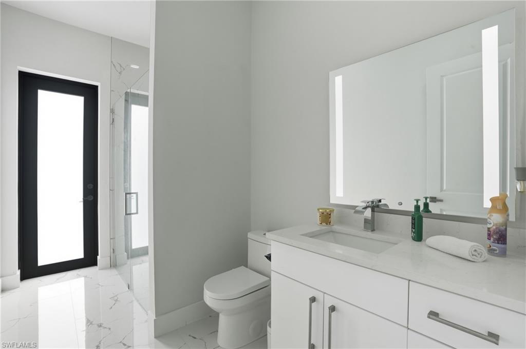 Full bathroom with vanity, light marble finish flooring, and a marble finish shower