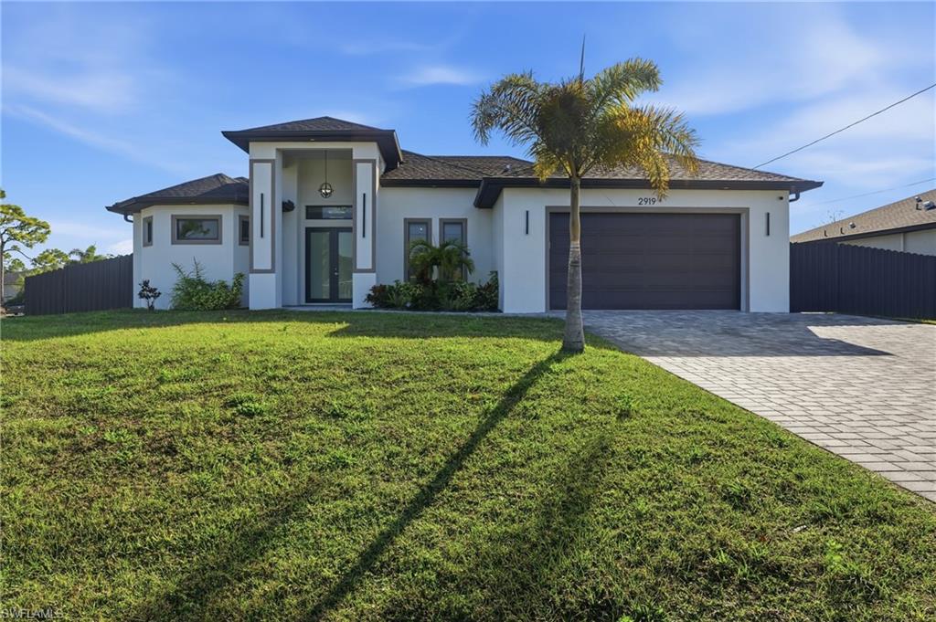 View of front of property featuring decorative driveway, stucco siding, a garage, and a shingled roof