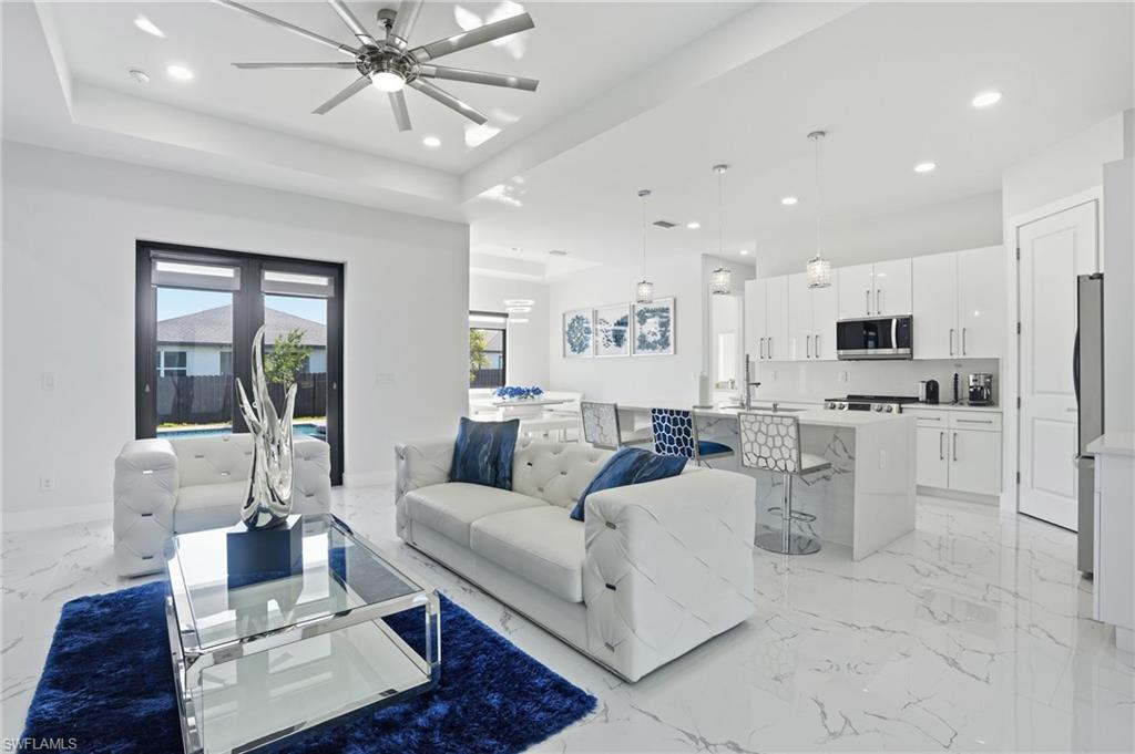 Living room featuring light marble finish flooring, recessed lighting, and a ceiling fan