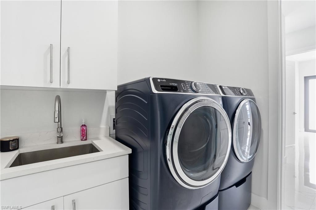 Laundry area with cabinet space and washer and clothes dryer