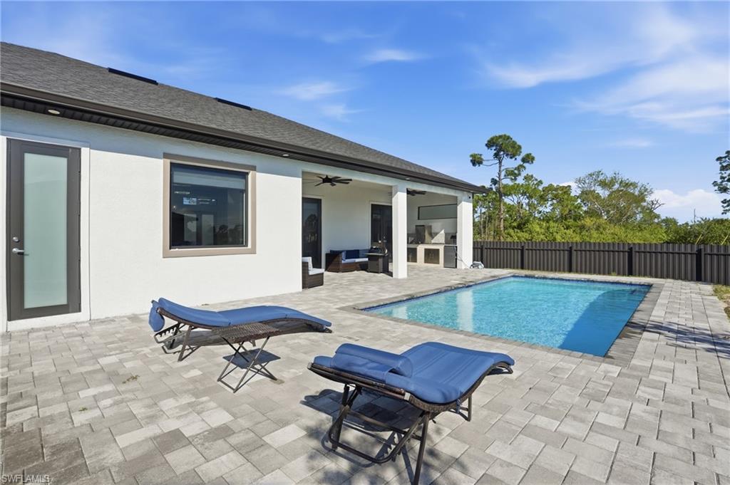 View of pool with patio surround and a fenced backyard