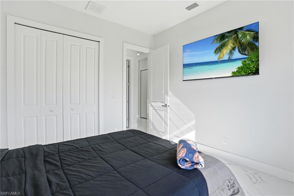 Bedroom with a closet and marble look tile flooring