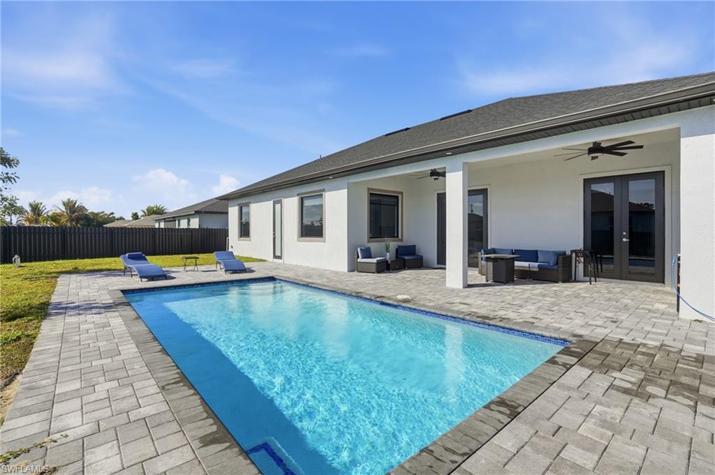 View of swimming pool featuring patio surround, an outdoor hangout area, a fenced backyard, and french doors