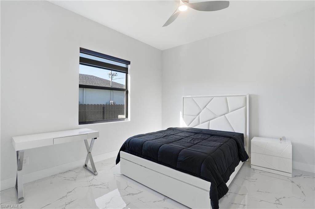 Bedroom with light marble finish flooring and a ceiling fan