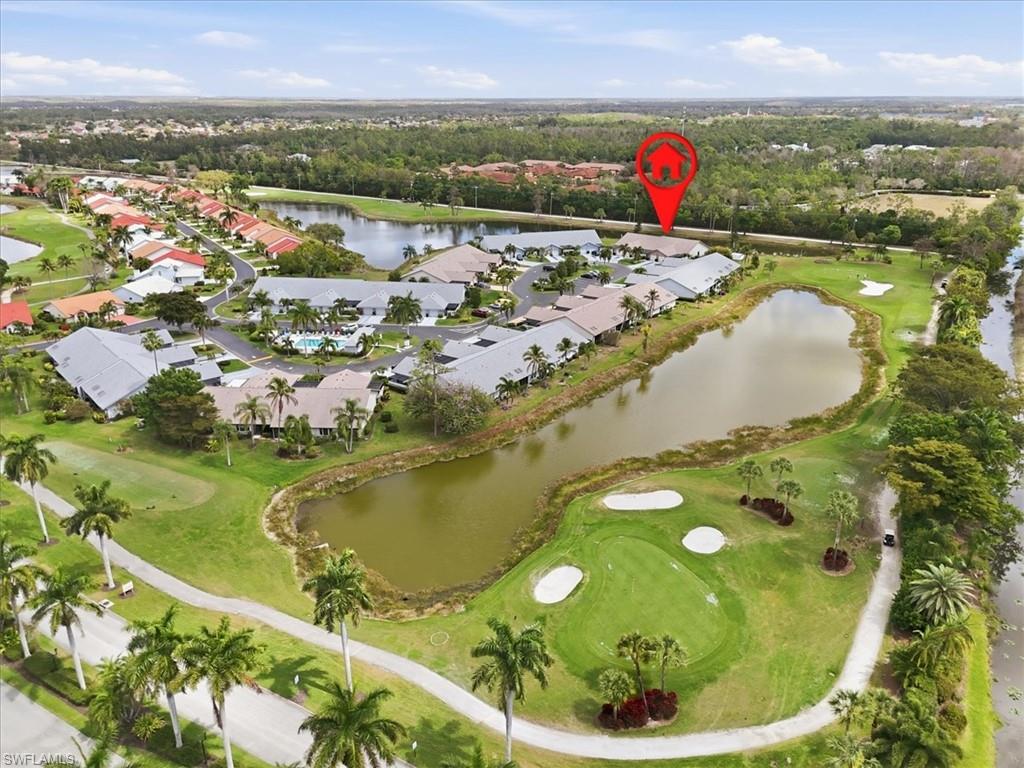 Aerial perspective of suburban area featuring a golf club and a large body of water