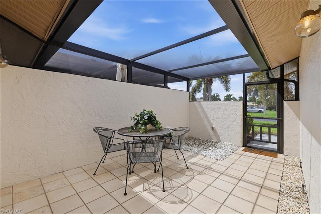 View of patio / terrace with a sunroom, outdoor dining area, and a lanai