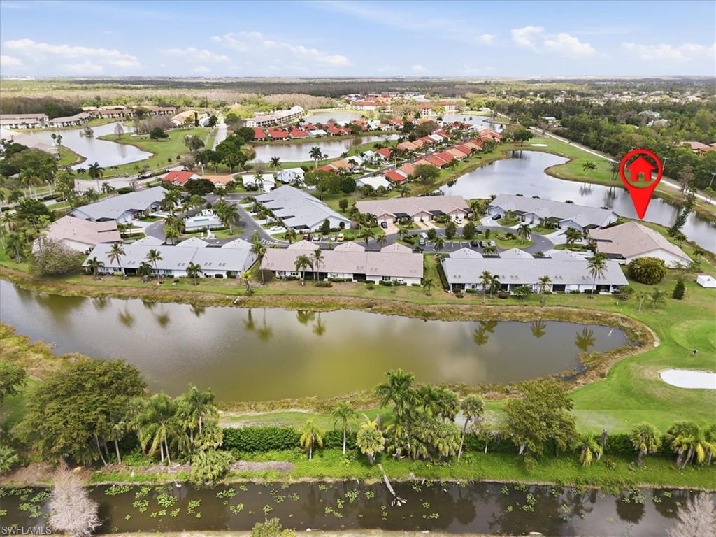 Aerial view of property and surrounding area featuring nearby suburban area and a nearby body of water