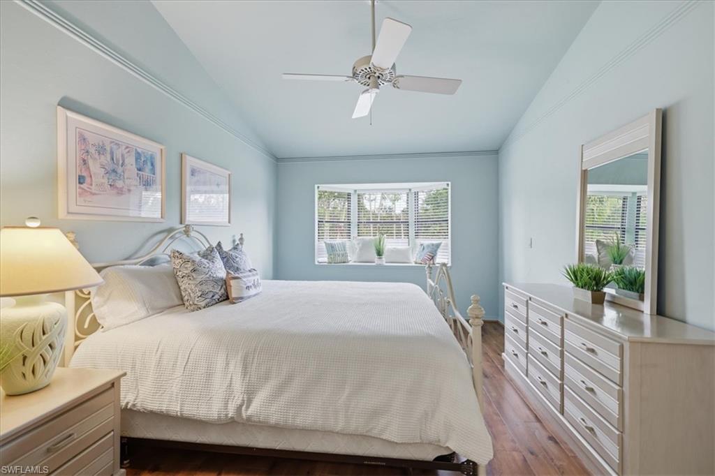 Bedroom featuring vaulted ceiling, dark wood-style floors, and ceiling fan