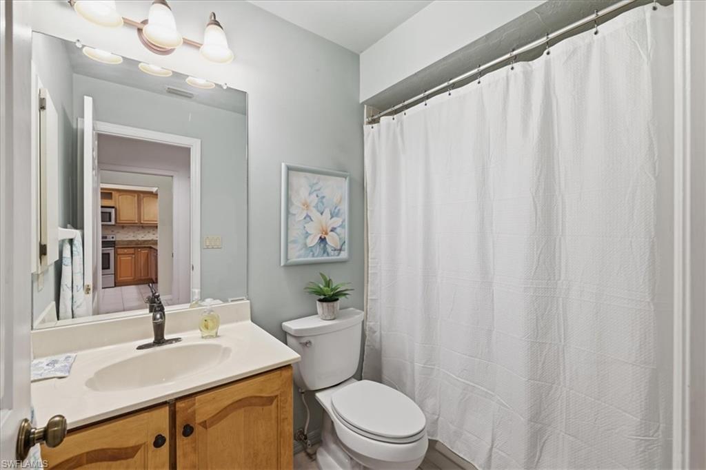 Full bath with a shower with curtain and vanity