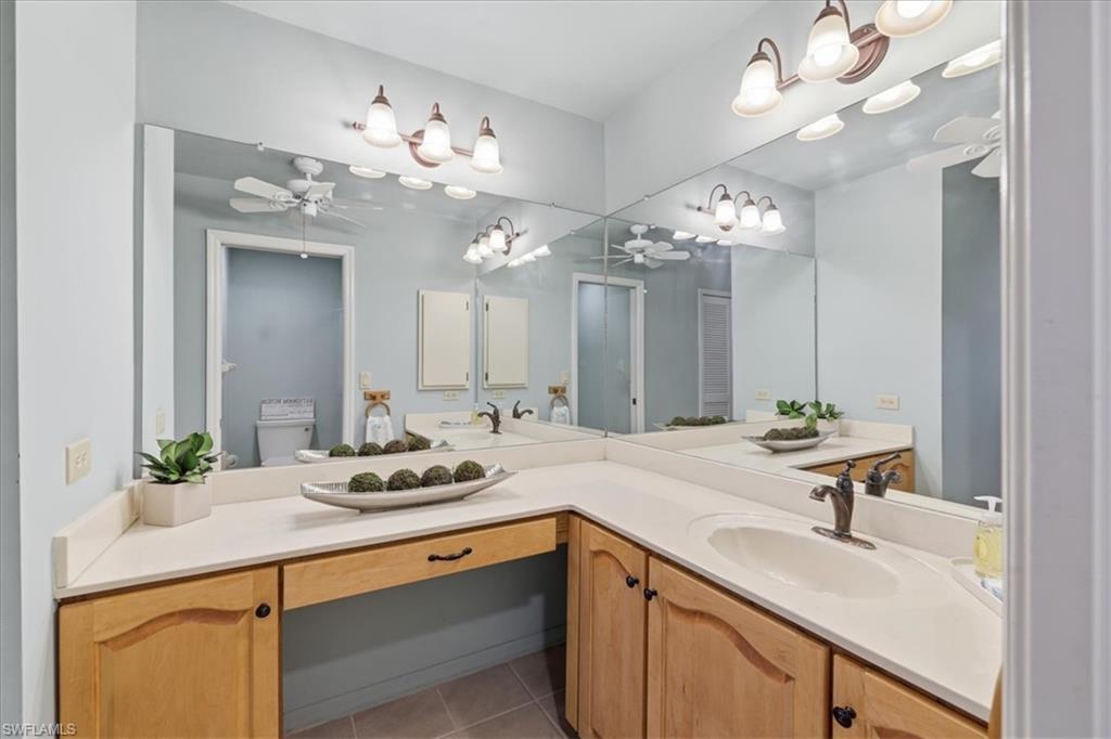 Full bathroom with a ceiling fan, vanity, and light tile patterned flooring