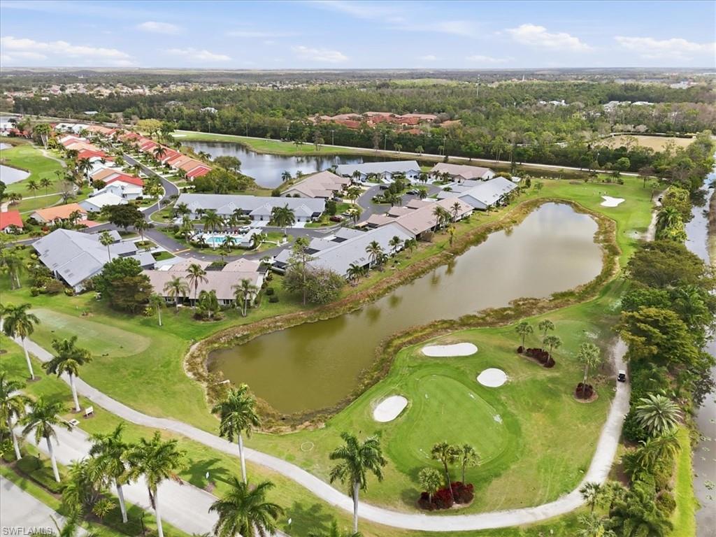 Aerial view of residential area featuring a golf club and a nearby body of water