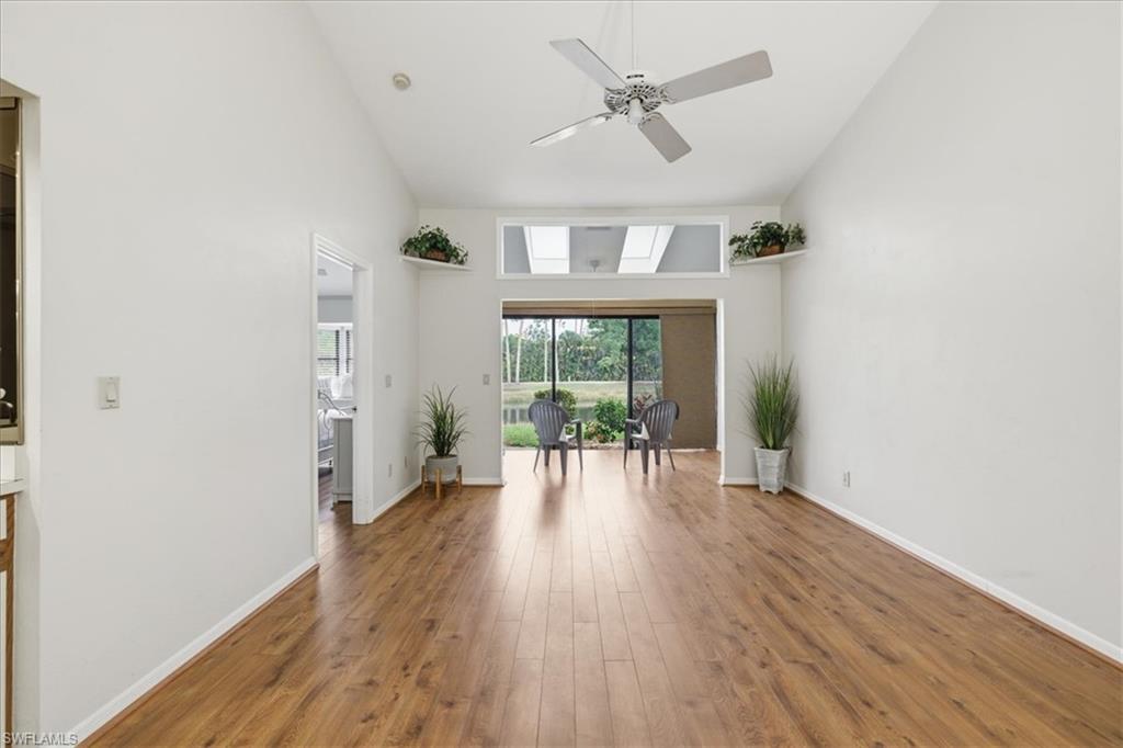 Living area with vaulted ceiling, ceiling fan, and wood-type flooring