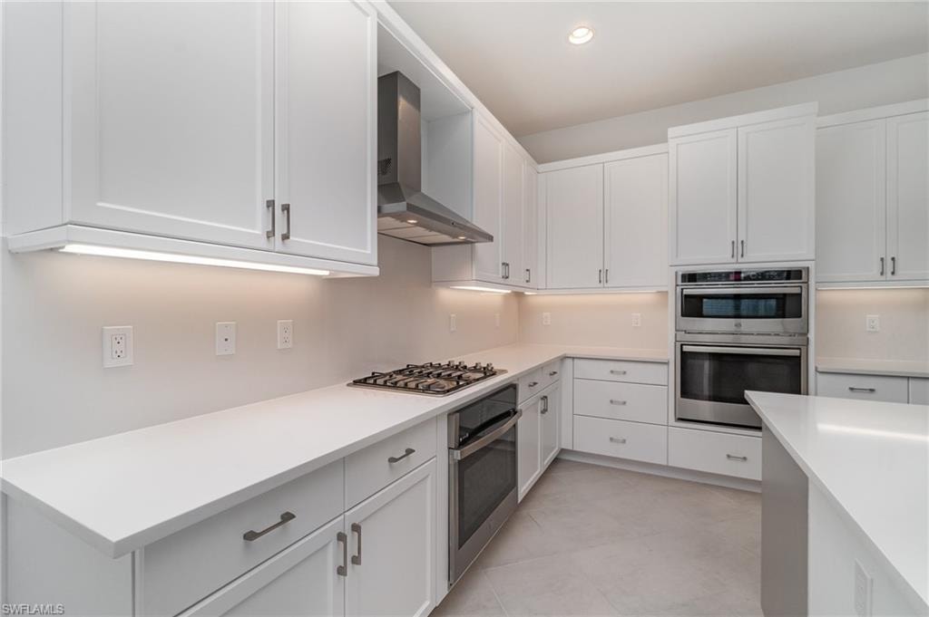 Kitchen with white cabinets, stainless steel appliances, and recessed lighting