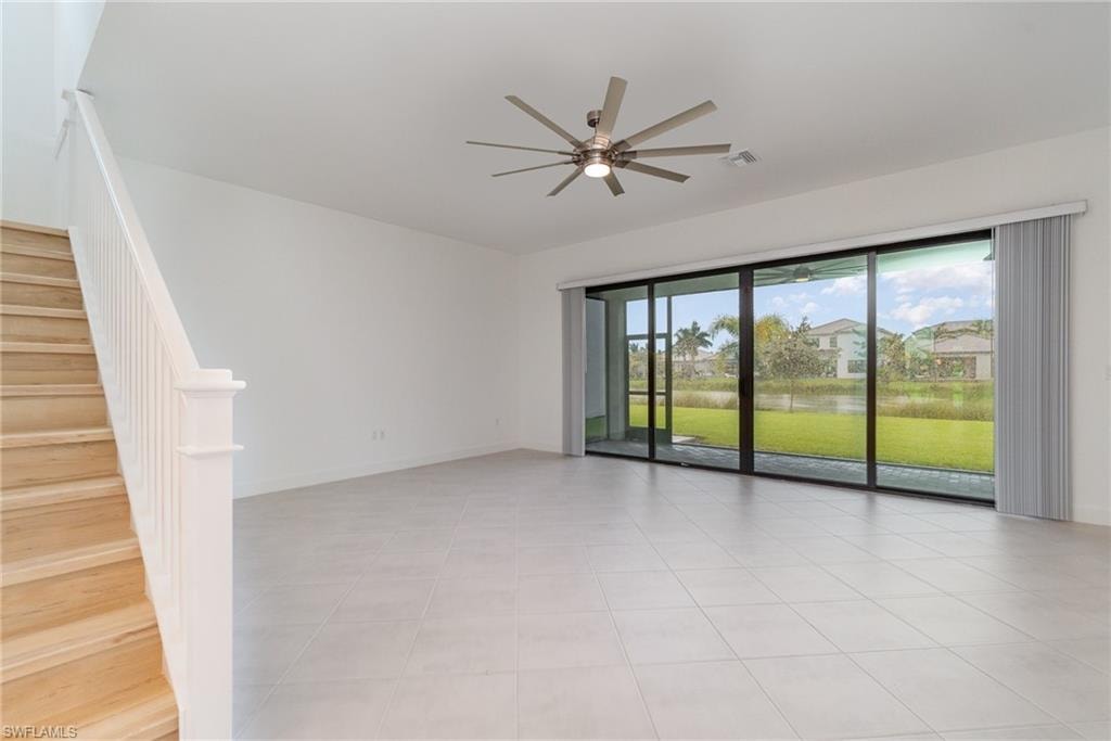 Unfurnished room featuring a ceiling fan, light tile patterned floors, and a residential view