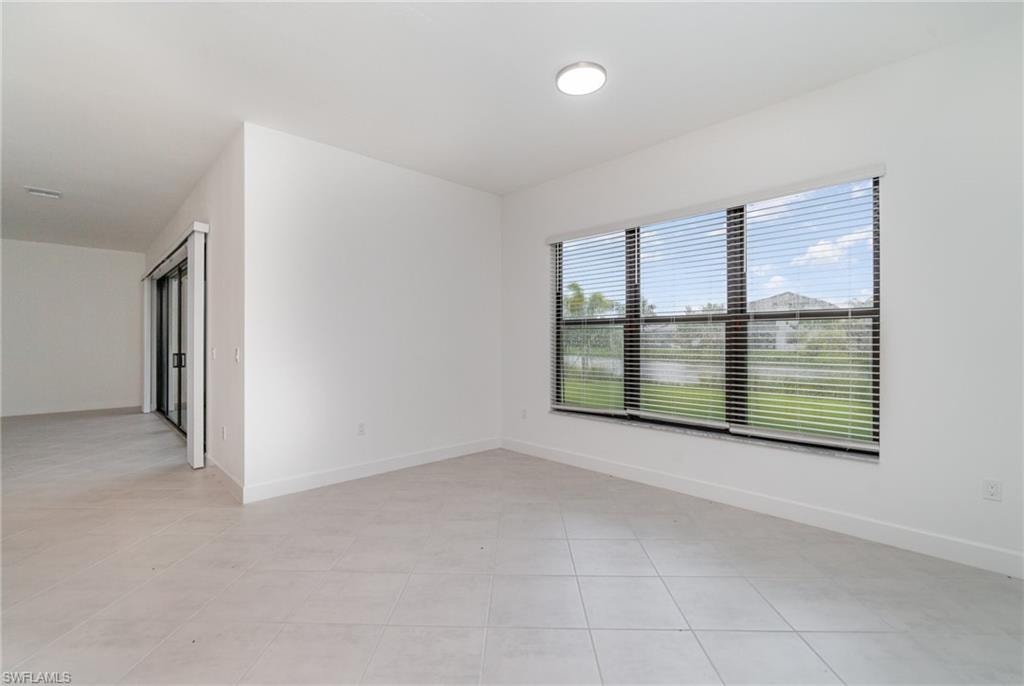 Spare room with baseboards and light tile patterned flooring