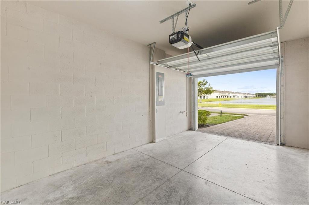 Garage with electric panel, a garage door opener, and a residential view