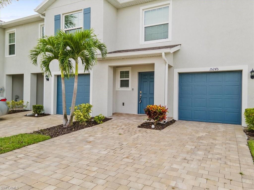 View of front facade with stucco siding, an attached garage, and driveway