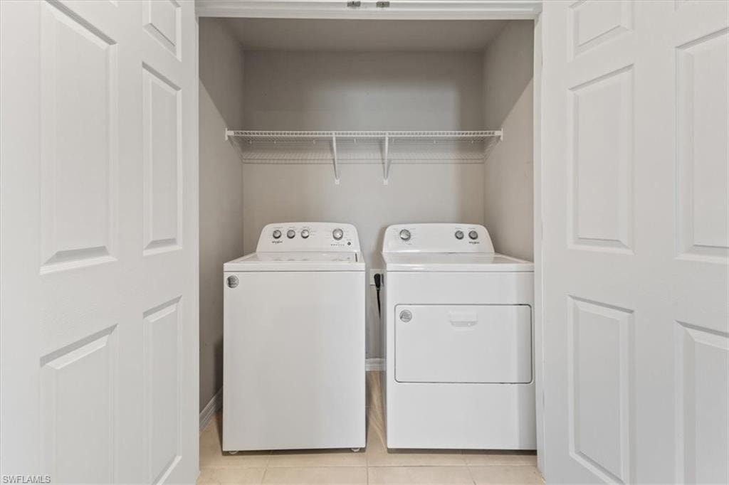Laundry area featuring washer and dryer and light tile patterned floors