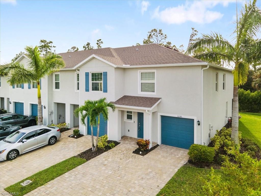View of front of home with a shingled roof, stucco siding, an attached garage, and driveway