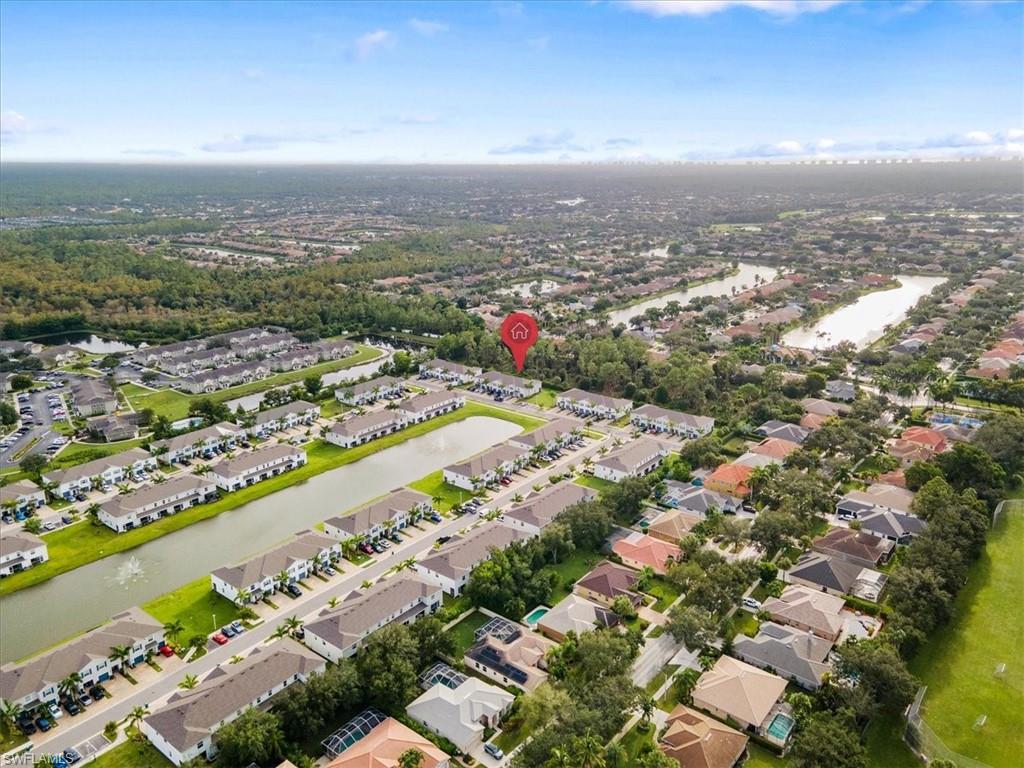 Aerial view of property's location with a nearby body of water and nearby suburban area