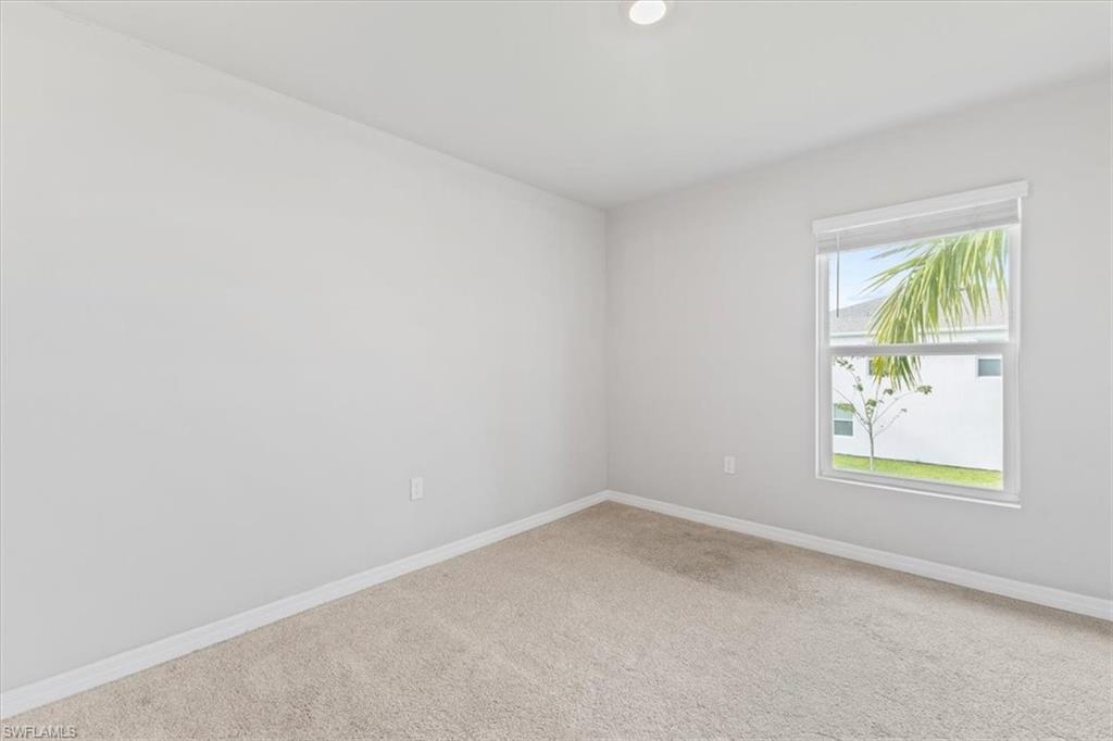 Spare room with baseboards and carpet