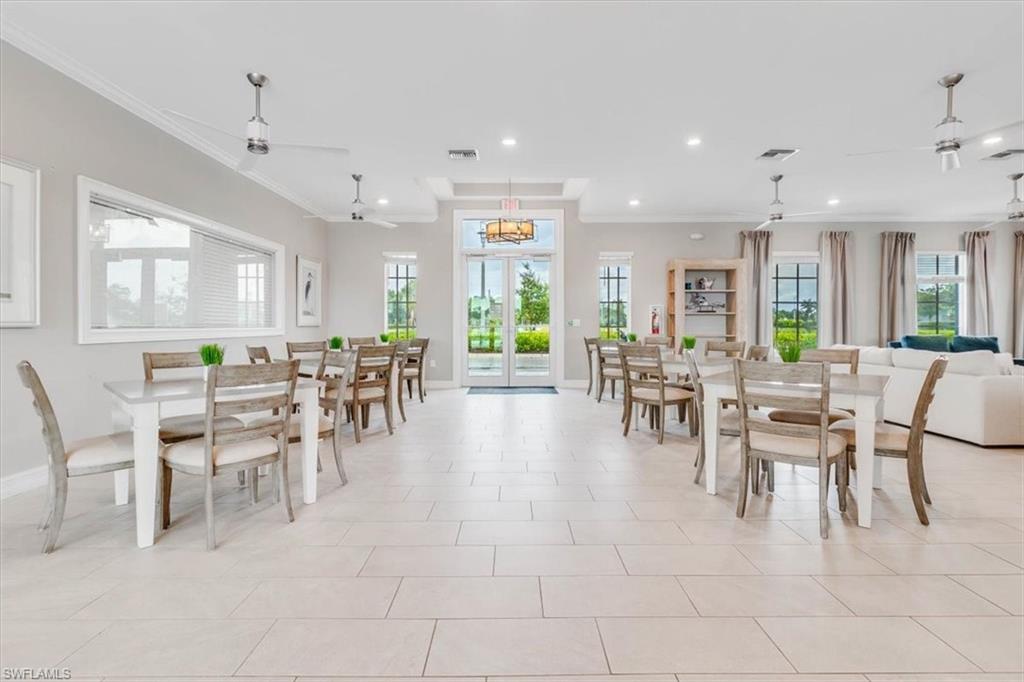Dining space with french doors, ornamental molding, light tile patterned floors, and recessed lighting