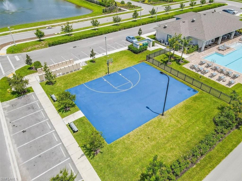 View of sport court featuring community basketball court, a fenced backyard, a water view, and a patio area