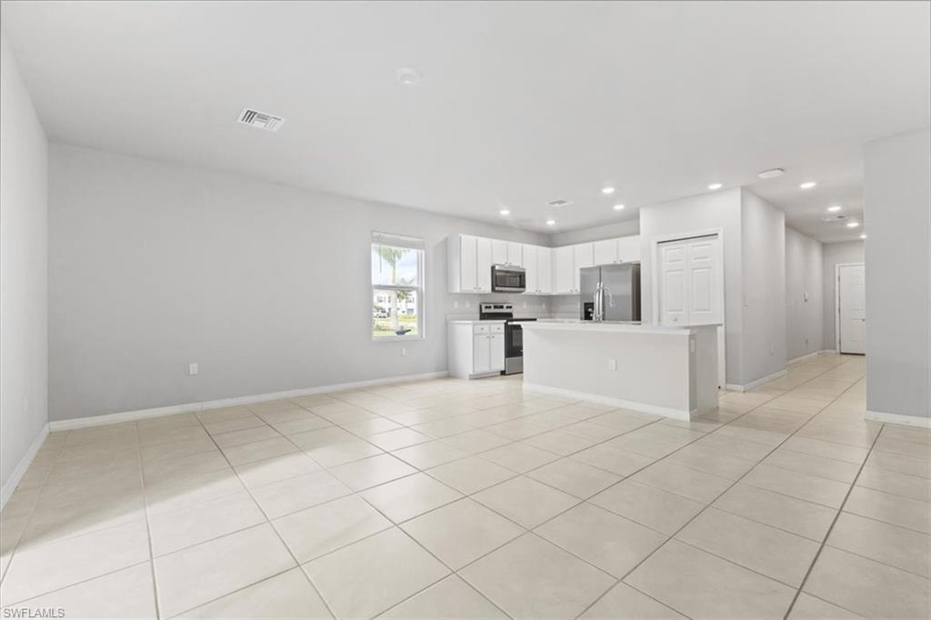 Unfurnished living room featuring light tile patterned floors and recessed lighting