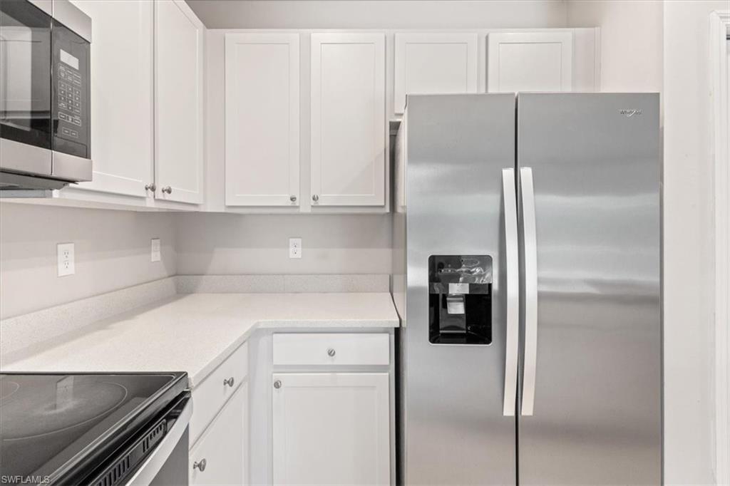 Kitchen with stainless steel appliances and white cabinetry