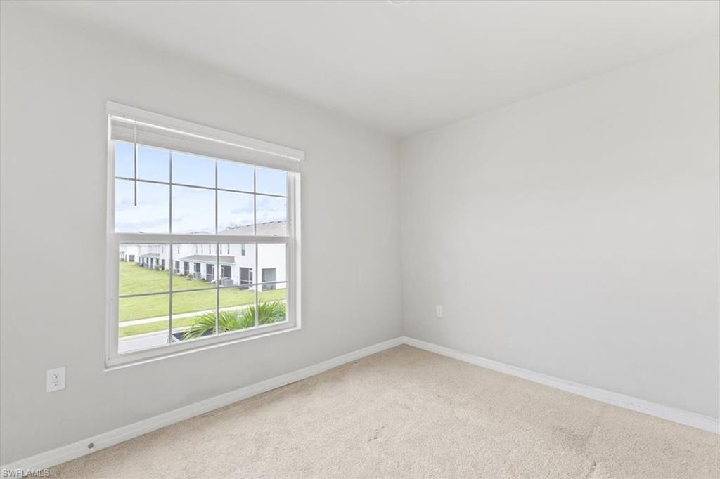 Spare room featuring baseboards and carpet flooring