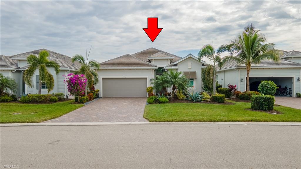 View of front of property featuring a garage and a front lawn