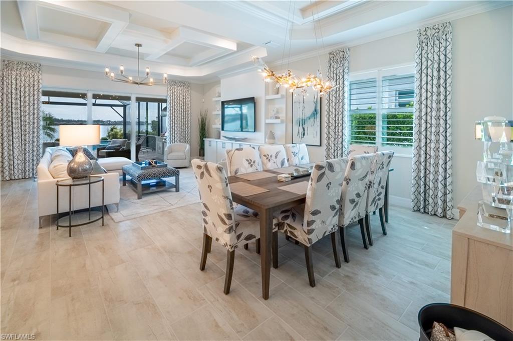 Dining room featuring beamed ceiling, crown molding, coffered ceiling, and a notable chandelier